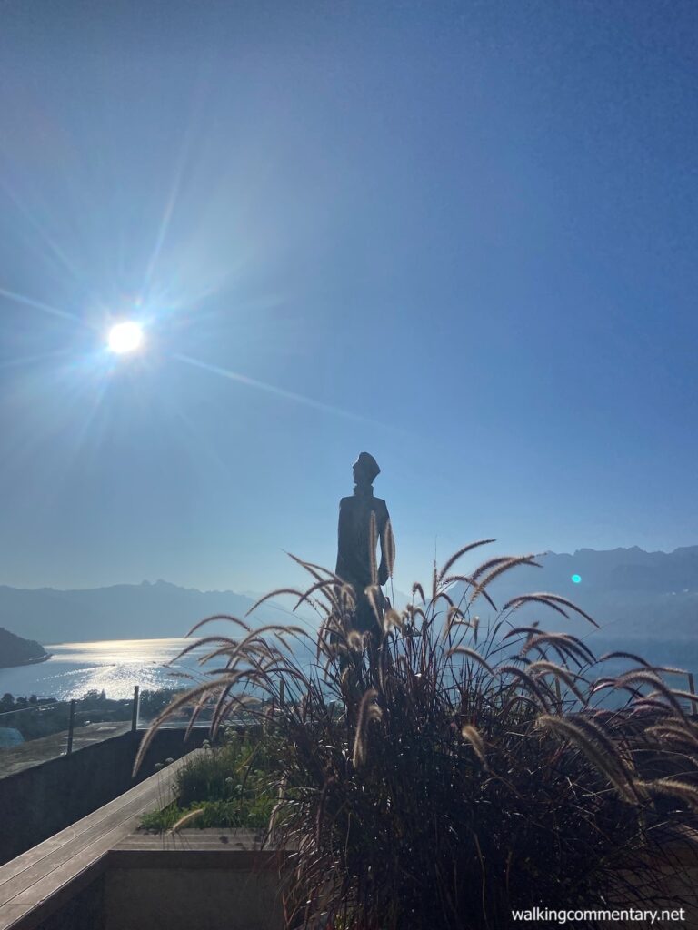 Day 14: Perfect Cycle - sun shining on the lake with a statue in the foreground